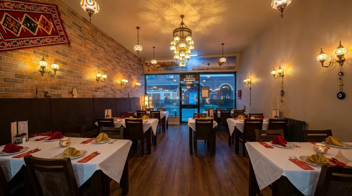 Lezzet dining room set for service beneath glowing Turkish mosaic lamps.